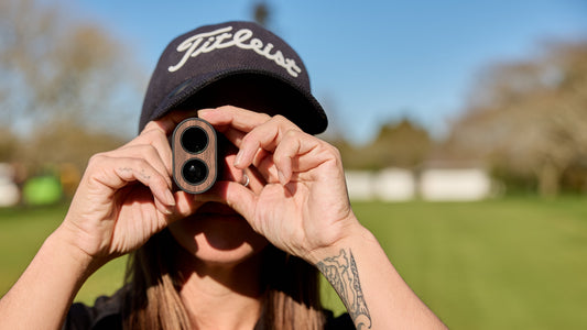 Close up of woman using a rangefinder on golf course